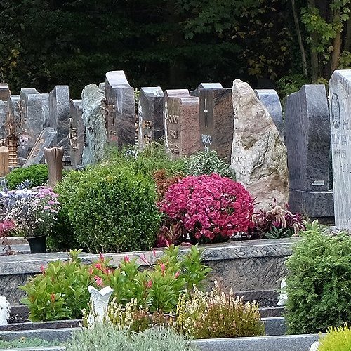 Reihe von Grabmalen und Gräbern auf einem Friedhof