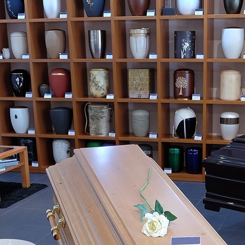 Urnenausstellung mit Sarg im Bestattungshaus