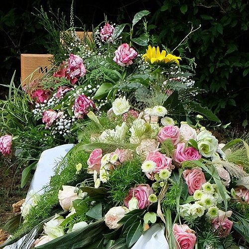 Blumenschmuck und Kränze auf der Grabstelle nach einer Bestattung