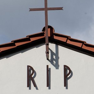 Kreuz und Schrift RIP am Giebel einer Trauerhalle